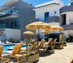 a group of chairs and umbrellas next to a swimming pool at Olga Studios in Kokkini Khanion