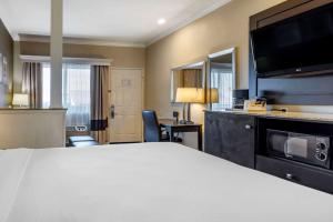 a hotel room with a bed and a flat screen tv at Comfort Inn & Suites Huntington Beach in Huntington Beach