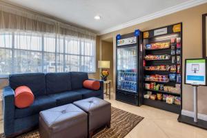 a living room with a blue couch and a soda machine at Comfort Suites San Clemente Beach in San Clemente