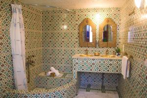 a tiled bathroom with a sink and a shower at Riad Lalla Fatima in Fez