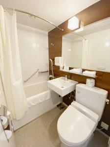 a bathroom with a white toilet and a sink at Hotel Rose Garden Shinjuku in Tokyo