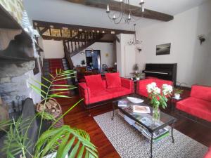 een woonkamer met rode banken en een tafel bij B&B Amphitryon in Oloron-Sainte-Marie