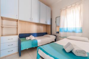 a bedroom with two beds and a dresser and a window at Ginestre S in La Maddalena