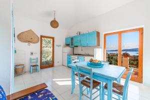 a kitchen with a blue table and chairs at Ginestre S in La Maddalena