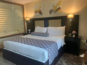 a hotel room with a large bed with white pillows at Olive Tree Amman in Amman
