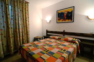 a bedroom with a bed with a colorful blanket at Apartament ARTS 3 in L'Estartit