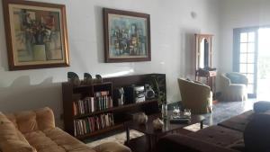 - un salon avec un canapé et une étagère à livres dans l'établissement Hospedagem Lirio, à Bragança Paulista