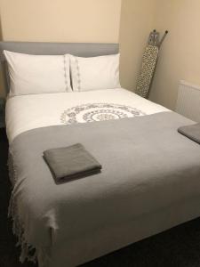 een groot wit bed met een bruine handdoek erop bij Hinton House in Liverpool