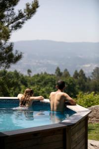 un hombre y una mujer sentados en una piscina en Traços D'Outrora, en Vale de Cambra