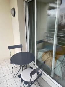 une table et deux chaises assises sur un balcon dans l'établissement Spacieux studio sans vis à vis, à Chelles