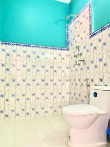 a bathroom with a toilet and a blue wall at Mountain Resort in Nagarkot