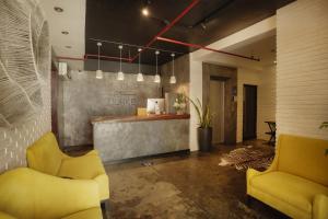 a lobby with two yellow chairs and a bar at The Bourke Hotel in Davao City