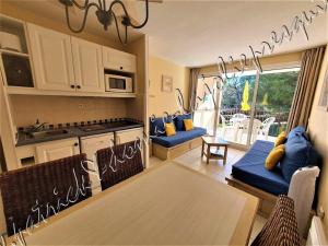 a kitchen and living room with a table and chairs at Magnifique Parc de la Presqu'île avec Piscine et Plage face à Porquerolles ! in Hyères