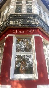 ein rotes Gebäude mit einem Fenster mit den Worten Clark in der Unterkunft Get-your-flat - Mansard-Wohnung in Villa 3 Zr Kü Bad, 85 m2, bis 4 Gäste , Haustier auf Anfrage - ruhig & naturnah - TOP in Hagen
