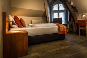 a bedroom with a large bed with a large window at Hotel De Limbourg in Sittard