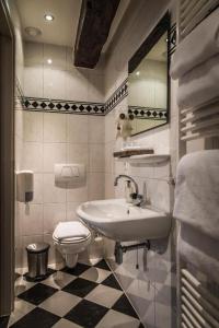 a bathroom with a sink and a toilet at Hotel De Limbourg in Sittard