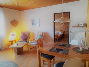 a living room with a dining table and a bedroom at Haus Schäfer in Menzenschwand