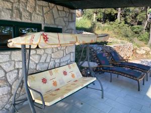 a table and chairs under an umbrella on a patio at Apartments Vila Vino in Sveta Nedelja