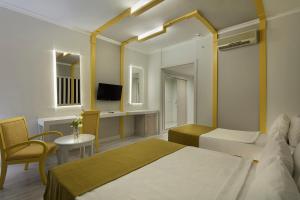 ベルディビにあるGrand Ring Hotelのベッド、テーブル、椅子が備わるホテルルームです。