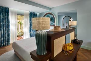 een slaapkamer met een bed en een tafel met een lamp bij Tropical Hotel St Barth in Gustavia