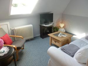 sala de estar con sofá, TV y mesa en FeWo Ostseestrand, en Neustadt in Holstein
