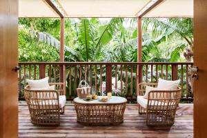 a porch with wicker chairs and a table on a deck at Tropical Hotel St Barth in Gustavia +81 photos