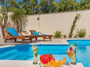 a table with fruit and drinks next to a pool at Apartments St Thomas in Dubrovnik