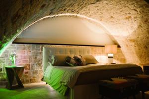 a bedroom with a bed in a stone wall at Apulia Suite in Castellana Grotte