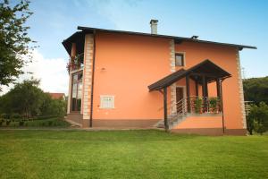 a house with a balcony with flowers on it at Rooms Marković in Otočac