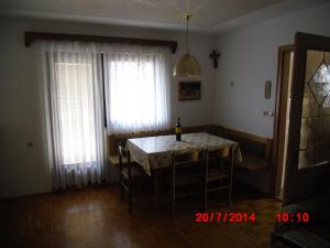a dining room with a table and chairs and two windows at Holiday Home Pri Srni in Bohinj