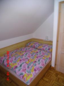 a bedroom with a bed with a colorful comforter at Holiday Home Pri Srni in Bohinj