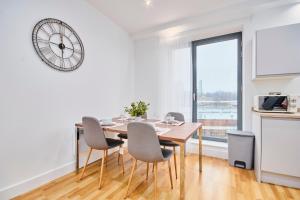 a dining room with a table and chairs and a clock at Large Duplex Penthouse - Parking in Leeds