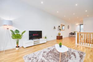 uma sala de estar com uma televisão e uma mesa em Large Duplex Penthouse - Parking em Leeds