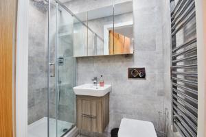 a bathroom with a sink and a shower at Large Duplex Penthouse - Parking in Leeds
