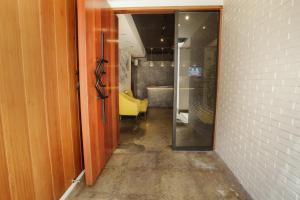um corredor com uma porta de vidro e uma cadeira amarela em The Bourke Hotel em Davao