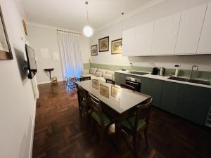 ローマにあるBB24 - 4 Fontane Private Suitesのキッチン(白いキャビネット、テーブル、椅子付)
