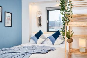 um quarto com uma cama com almofadas azuis e brancas em Large Duplex Penthouse - Parking em Leeds