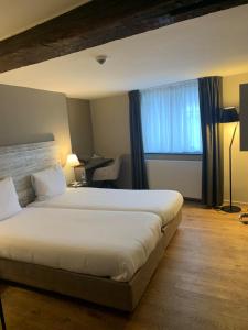 Postel nebo postele na pokoji v ubytování Hotel Au Quartier