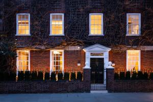 una casa de ladrillo con puerta delantera por la noche en Flawless Eight-bedroom Cheyne Family home in the heart of Chelsea en Londres