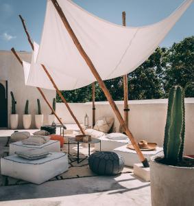 a patio with a white umbrella and a cactus at Ambre & Epices Jungle Hotel & Spa in Tulum