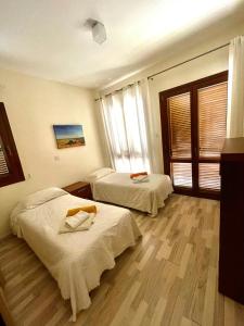 twee bedden in een kamer met houten vloeren bij Aphrodite Hills in Kouklia