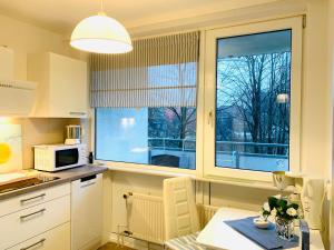 une cuisine avec une table et un four micro-ondes ainsi qu'une fenêtre dans l'établissement City Apartment 09, à Itzehoe