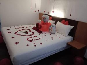 a bed witheddy bears and hearts on it at Nu Melati Hotel in Pantai Cenang