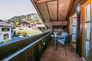 a balcony of a house with a table and chairs at Haus Sonnenrose in Reit im Winkl