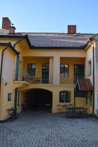 een groot geel gebouw met een patio ervoor bij Hauser-Bodnár Ház in Eger