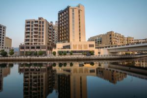 a city with tall buildings next to a body of water at Citadines Culture Village Dubai, Waterfront Jadaf in Dubai