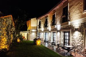 een gebouw met tafels en stoelen in een tuin 's nachts bij Pintura Urla Hotel in Urla