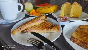 a table topped with plates of sandwiches and fruit at Pousada Recanto das Maritacas in Brotas
