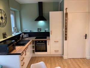 uma cozinha com um frigorífico branco e um fogão em Appartement cosy en duplex à 50m de la plage em Le Portel