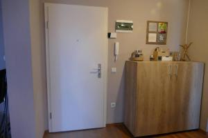 a white door in a room with a wooden cabinet at Apartament in cartier Avantgarden cu semineu! in Braşov